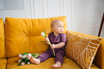 child on a yellow sofa with flowers at home