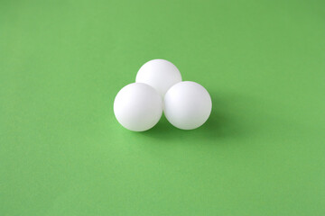 Ping pong balls on a green background.