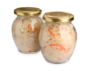 Glass jars of tasty fermented cabbage with carrot on white background