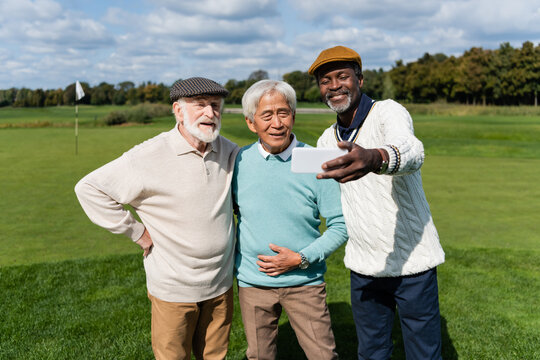 happy african american man taking selfie with senior interracial friends.