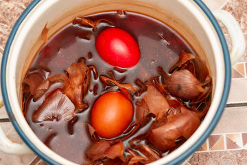 the traditional painted of red Easter eggs, in water with onion peels in Romania, Bistrita