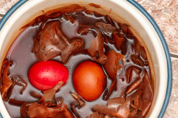 the traditional painted of red Easter eggs, in water with onion peels in Romania, Bistrita