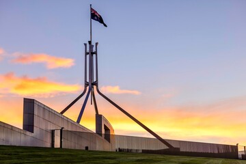 Australian Parliament House Canberra Australian Capital Territory. Showing the roof at sunset and the Australian Flag - obrazy, fototapety, plakaty