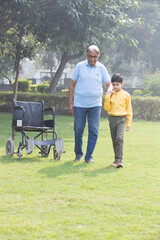 Grandson talking with grandfather in hospital garden