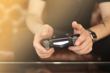 Playing games concept. Part body man with joystick play game on console playstation. Male hands holding pad.