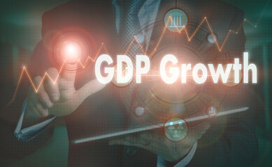 A businessman operating a computer display with a GDP Growth business word concept on it.