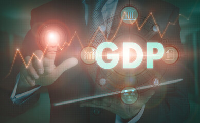 A businessman operating a computer display with a GDP business word concept on it.