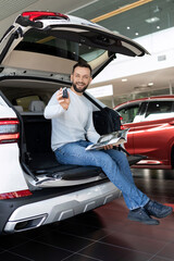 a satisfied customer demonstrates the keys of a new SUV