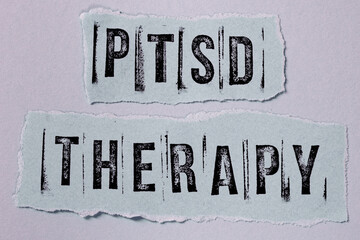 PTSD therapy inscription written on torn paper. Posttraumatic stress disorder therapy concept.