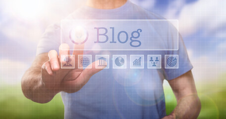 A man in a t-shirt outside selecting a Blog word concept on a computerised display