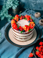 Naked cake with cream, decorated with berries.