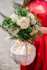 Bridesmaid in red dress holding bouquet. Closeup