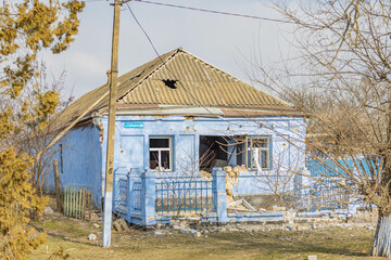 Fototapeta na wymiar Barmashovo, Ukraine- March 18, 2022: War of Russia against Ukraine. Concept of Russian invasion. Ruined and damaged house in the center of the village after bomb explosion through a window and roof. 