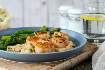 Pan-fried scallops with cauliflower and bean puree and asparagus