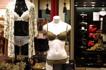 Female mannequins in lace bra and panties. Racks with sexy underwear in lingerie store