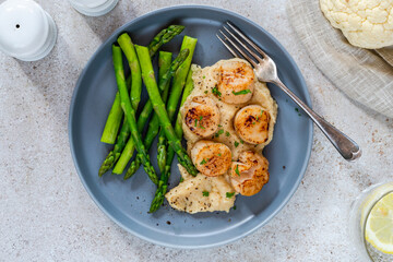 Pan-fried scallops with cauliflower and bean puree and asparagus
