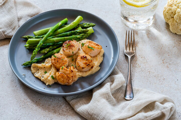 Pan-fried scallops with cauliflower and bean puree and asparagus