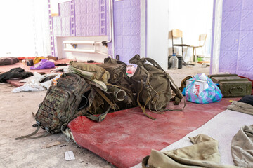  Dirt and trash, garbage and backpacks in the half-destroyed school hall after Russian invasion, they lived on the school mats and slept here.  