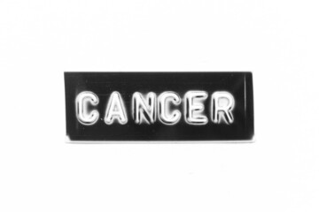 Black color banner that have embossed letter with word cancer on white paper background