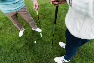 high angle view of senior men standing with golf clubs.