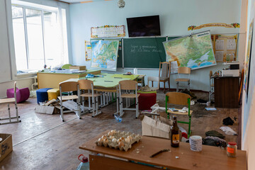  Dirt and trash, garbage in half-destroyed school room after Russian invasion. Windows are broken. ...
