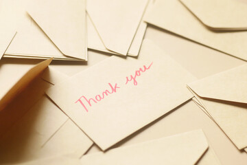 thank you message and envelope on wooden table 