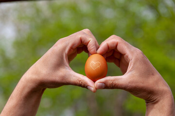 Ei mit Herz von H&auml;nden gehalten