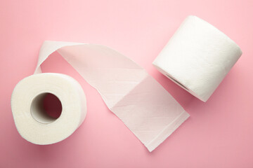 Roll of toilet paper on pink background.