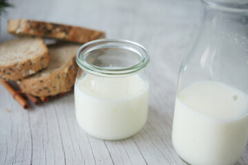 Close up of glass of milk and brown bread on table 