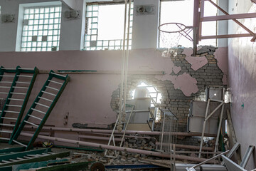 Barmashovo, Ukraine- March 18, 2022: War of Russia against Ukraine. Concept of Russian invasion. Bombed and devastated sport hall in a school after explosion of 2 bombs in the gym. Holes in the wall 