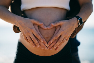 barriga de mujer embarazada con manos de los padres