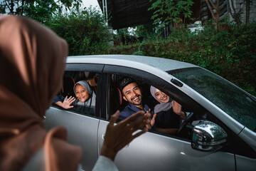 asian family coming home to their parent's house by car during idul fitri celebration