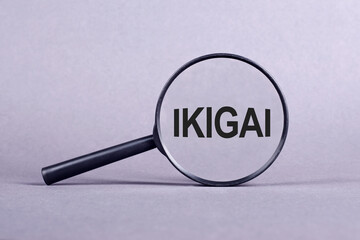 Magnifying glass with the inscription IKIGAI on a light gray background.