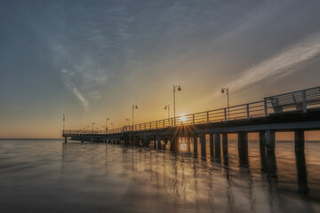 Fototapeta na wymiar Sunset over a wooden pier in Jurata, Baltic Sea, Poland. 