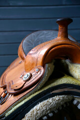 Horse mount. Horse saddle on wooden stand. Mounting accessory. Leather, metal and wool frame....
