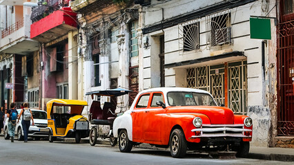 Orange retro car taxi and people passers-by in the old center of Havana