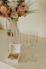 Bridal bouquet, ring box and champagne glasses.