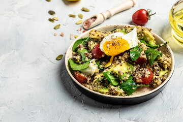 Quinoa buddha bowl with avocado, egg, tomatoes, spinach and sunflower seeds on a light background. Homemade food. Healthy, clean eating. Vegan or gluten free diet, Long banner format. top view