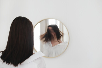 young woman looking in the mirror. Mental health problems in self-isolation at home. Depression,...