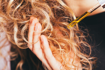 Close-up young woman applying pipette oil