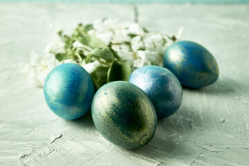 blue painted easter eggs and cherry blossoms on the table