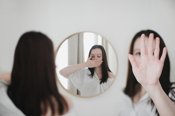 young woman looking in the mirror. Mental health problems in self-isolation at home. Depression,...