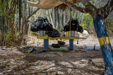 Diving gear on a painted bench in the shadow of a tree at Playa Jeremi on the Caribbean island Curacao