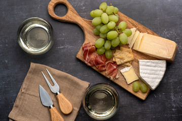 Food photography of white wine, cheese, grape, prosciutto