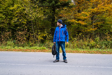 Man with a backpack stay on a forest road

