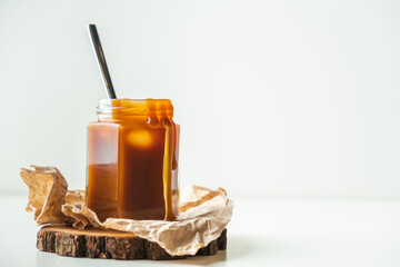 Salted caramel in the glass jar on the white background