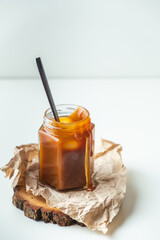 Salted caramel in the glass jar on the white background
