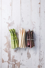 Green, white and purple asparagus on a kitchen background - 500450467