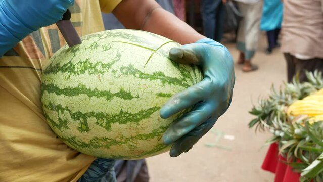 young men cutting water melon outdoor 