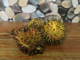 Fresh and ripe rambutan sweet tropical fruit peeled rambutan with leaves, Rambutan fruit on wooden background harvest from the garden